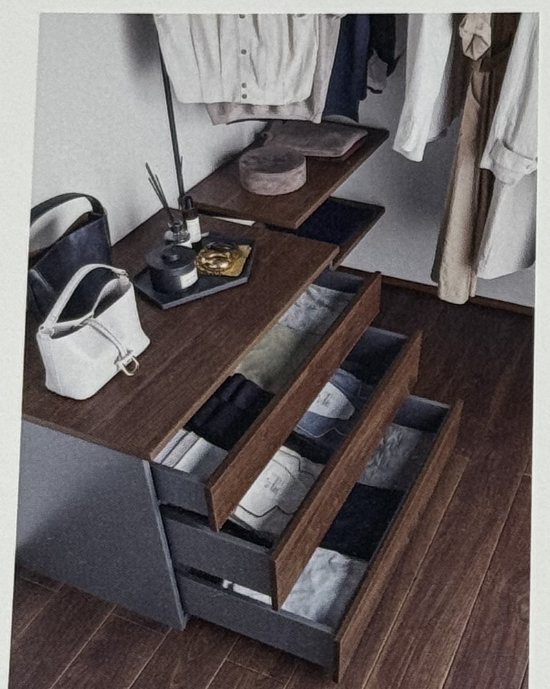 Next Walk-in Closetの引き出し収納。濃い木目のカウンター下に、取っ手のない引き出しが開いた状態で並んでいる
